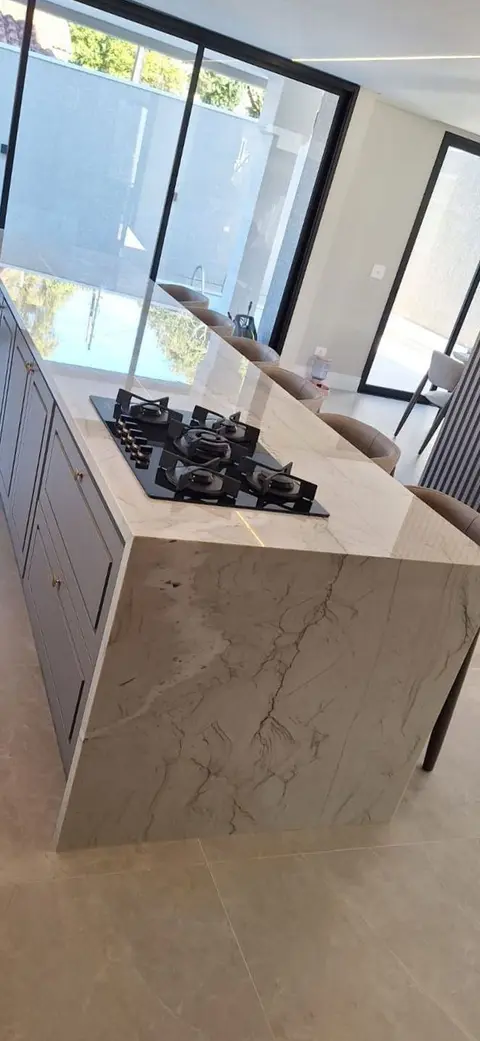 Ilha com cooktop e lateral em pedra de veios marcados