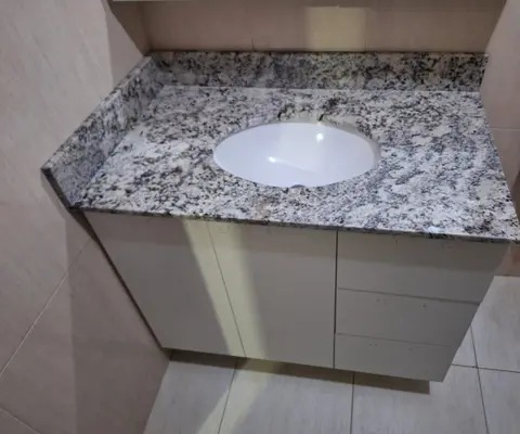 Lavatório em granito com cuba oval embutida e frontão